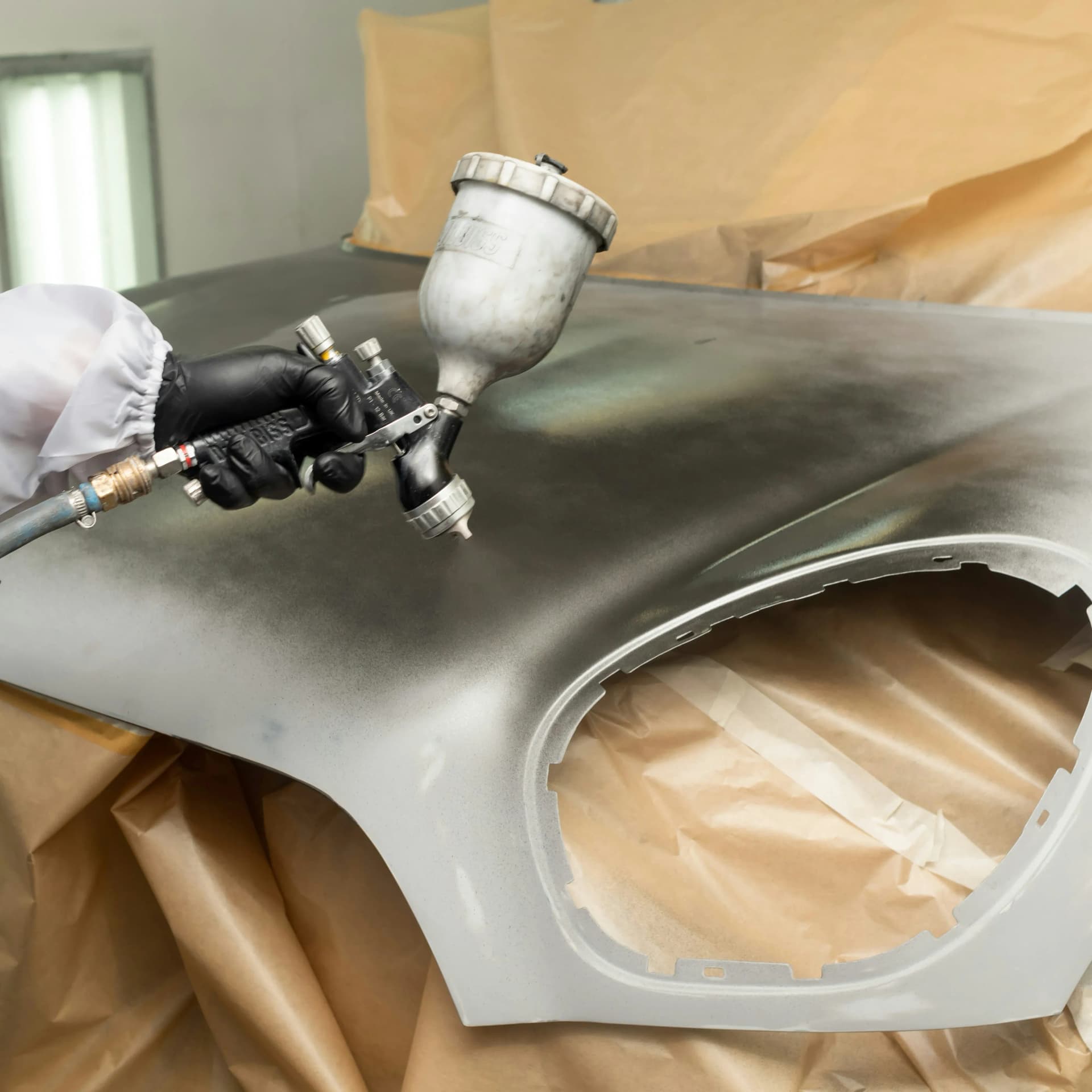 Industrial coatings specialist applying protective coating to a steel column inside a commercial facility.