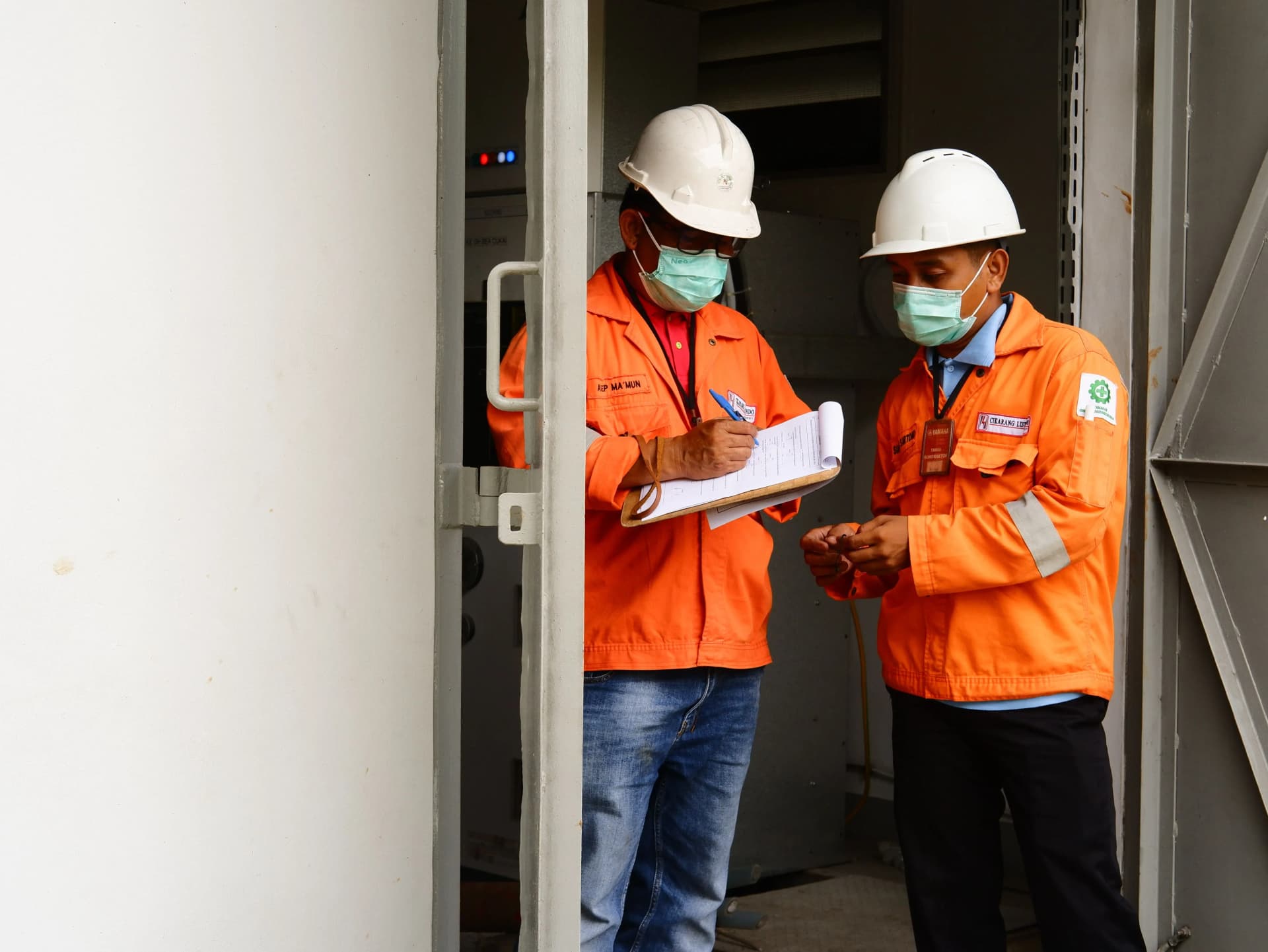 Two workers discussing compartmentation survey work on site