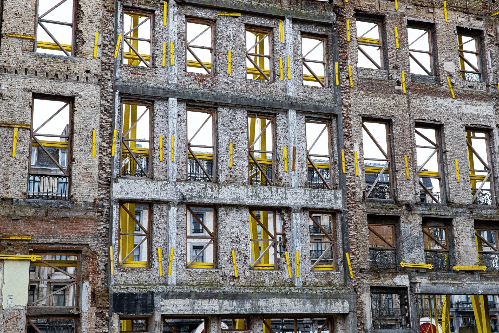 Temporary facade retention support system around an existing building