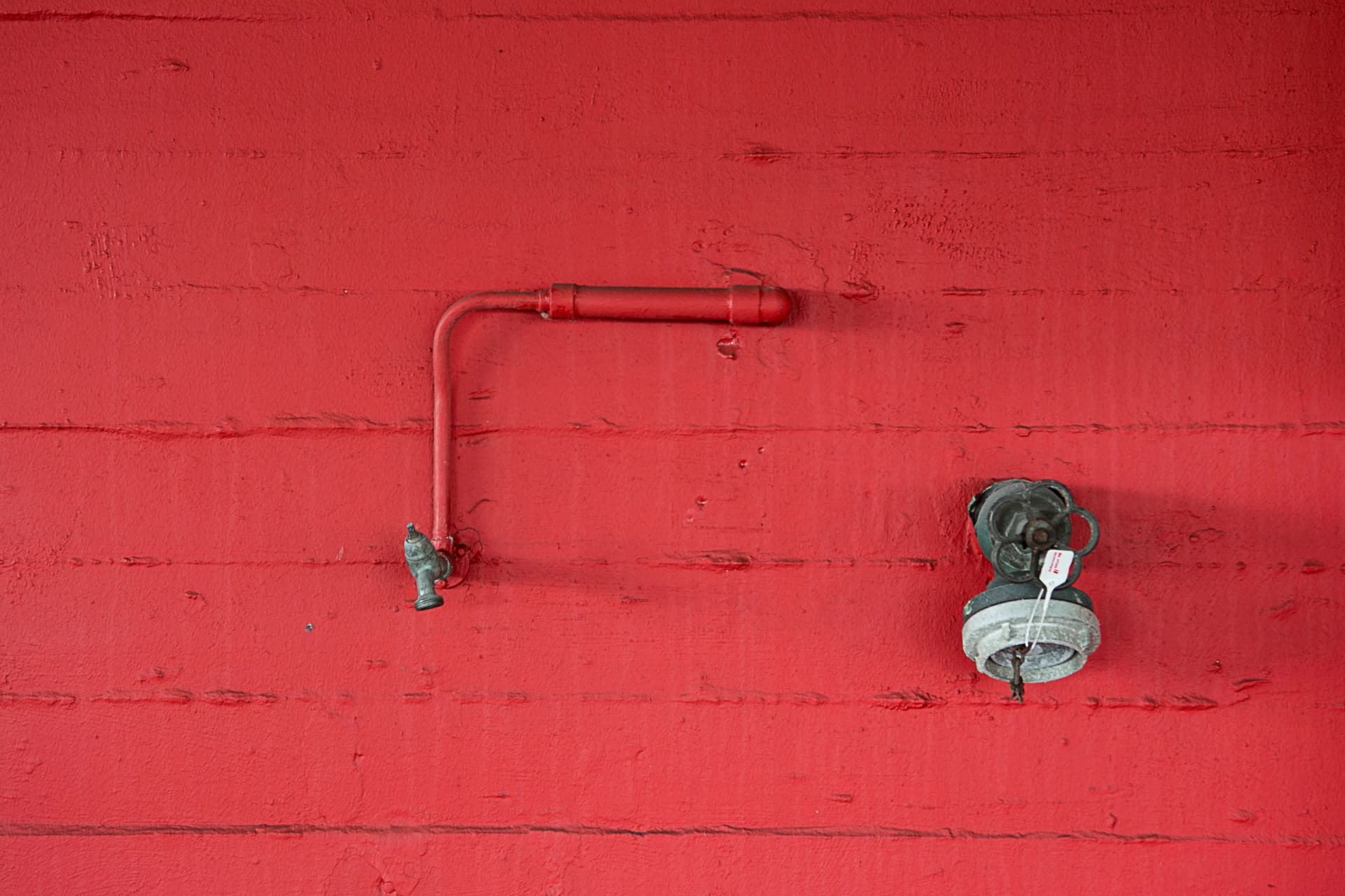 Fire sprinkler system installed on a red wall