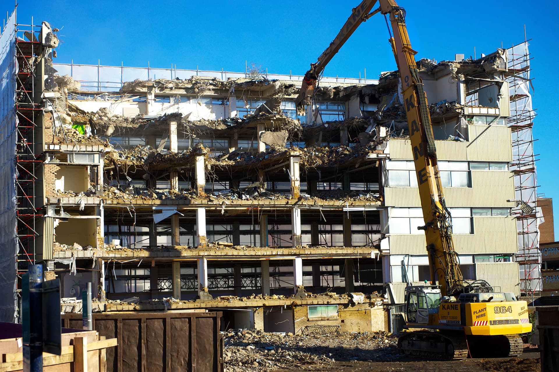 Industrial building being safely demolished using heavy equipment