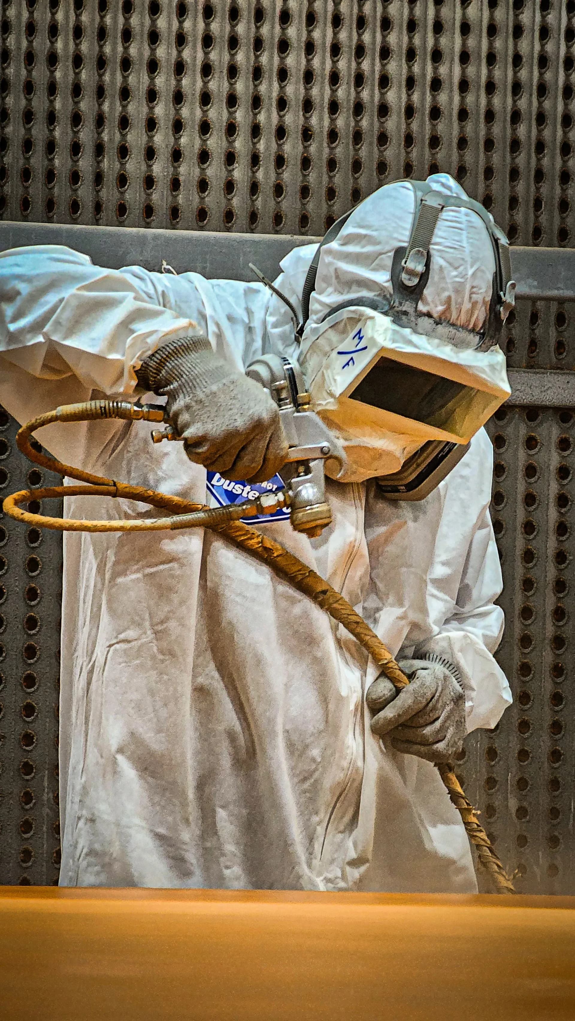 Worker spraying intumescent coating onto structural steelwork