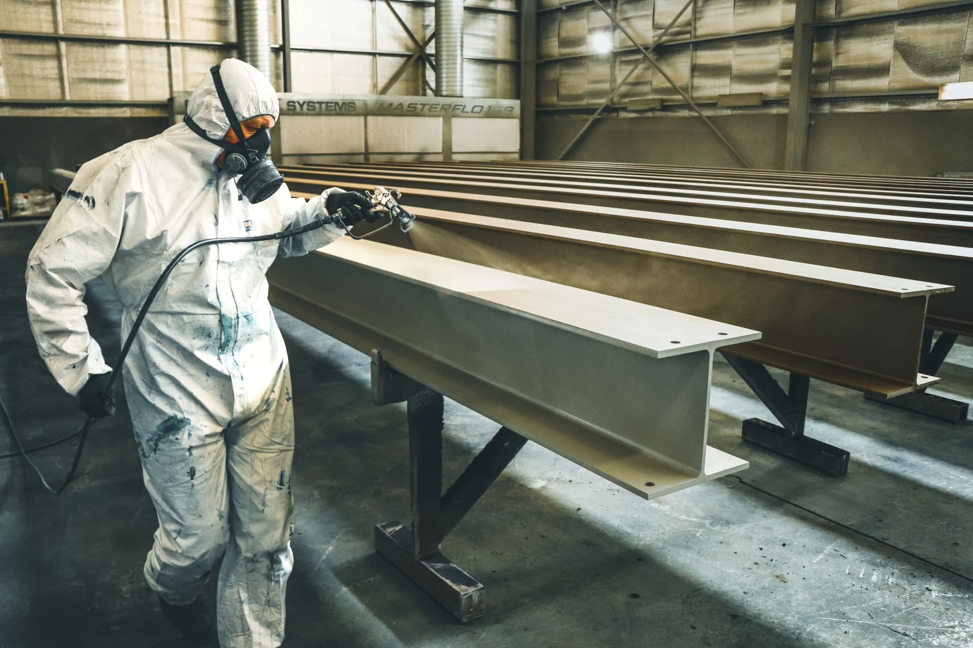 Worker applying intumescent coating to structural steelwork