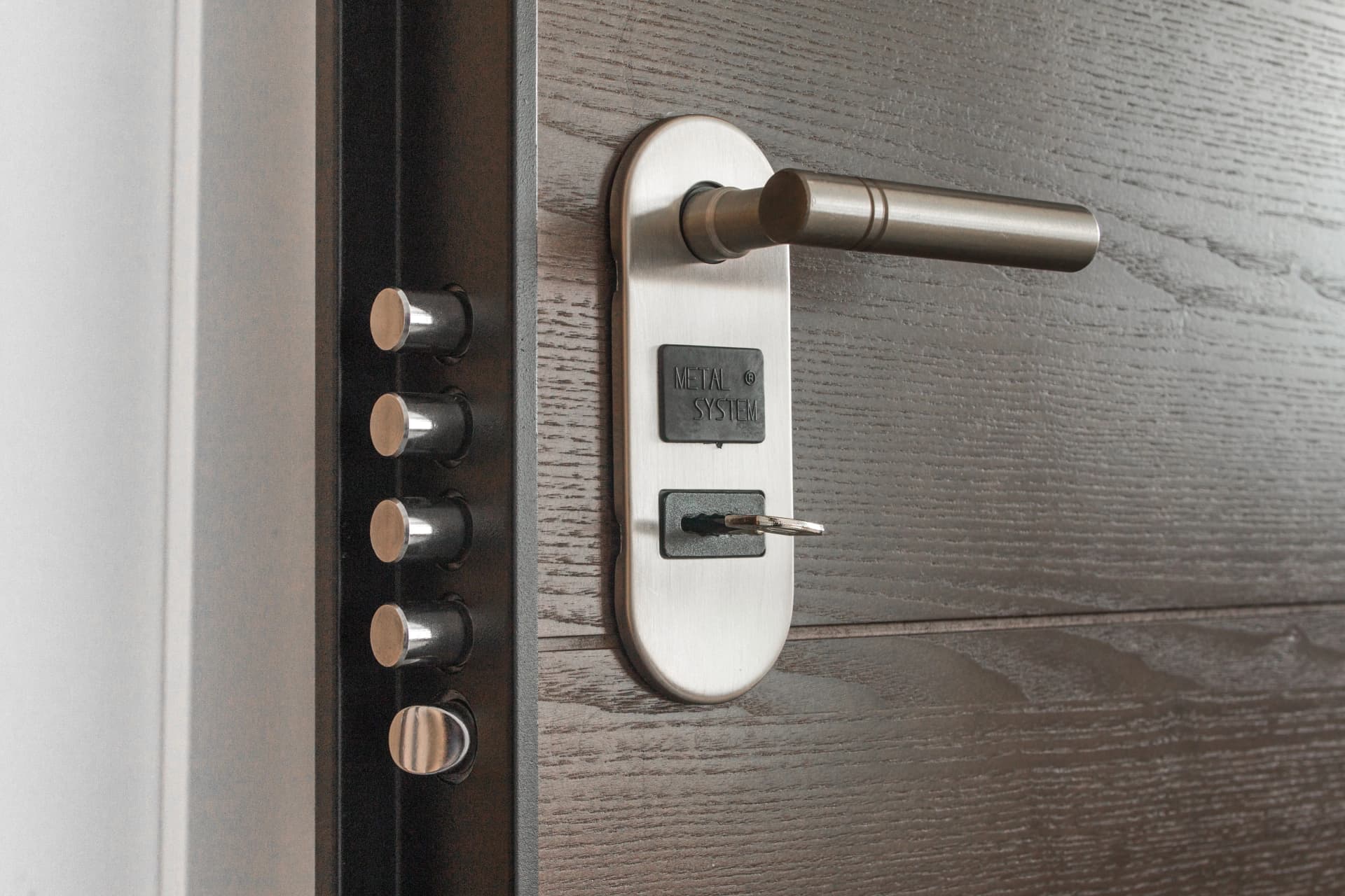 Close-up of a modern dark wooden door with a brushed metal handle