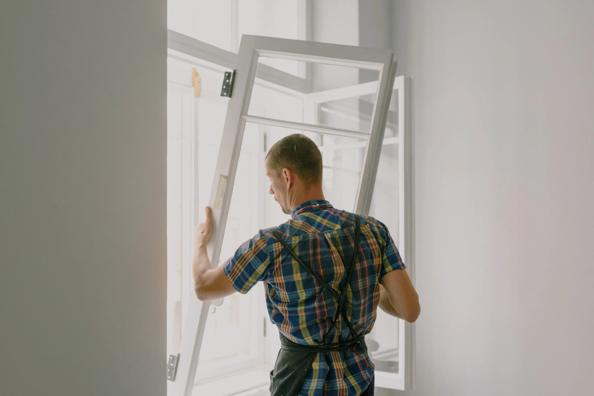 Installer carrying out window fitting in a residential property.